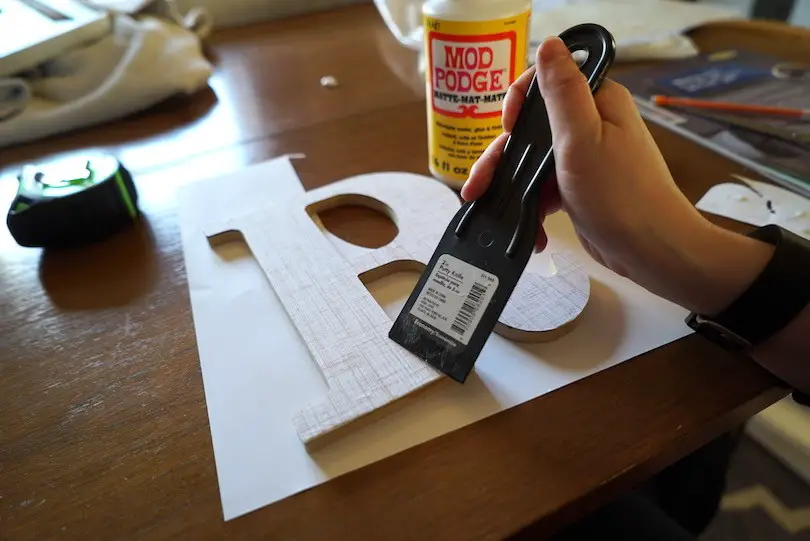 DO: Smooth out the paper with a putty knife or roller to get all the air bubbles and extra Mod Podge out.